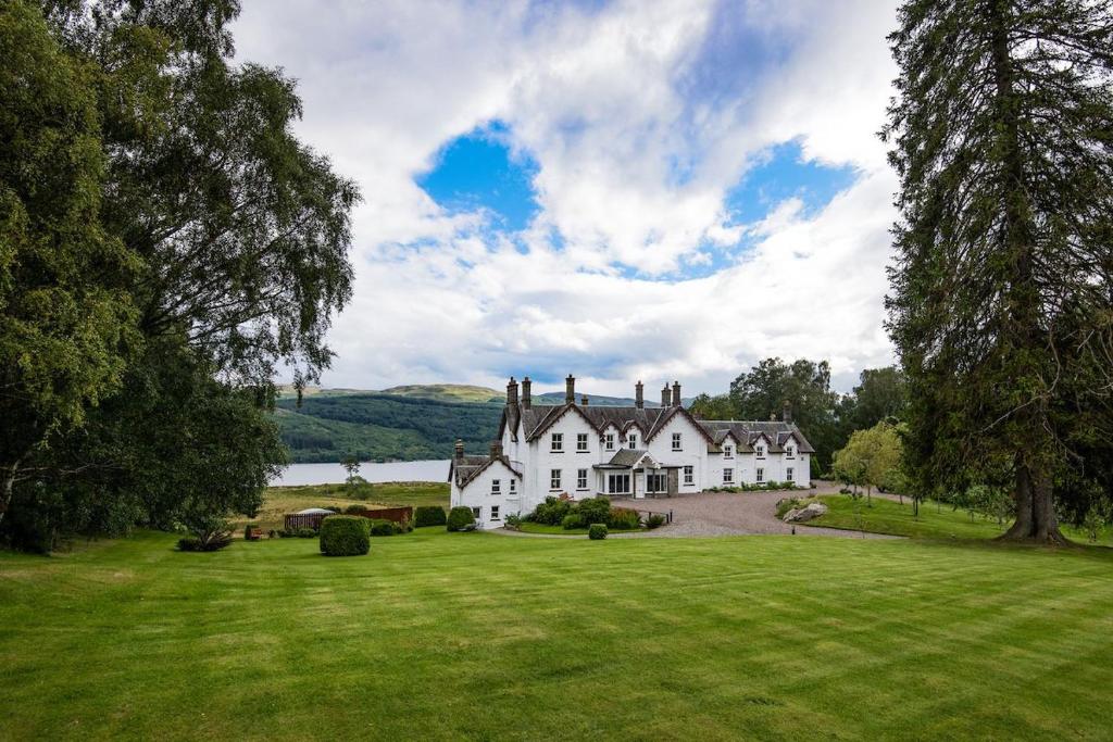 a large white house on a green field at Stucktaymore in Killin