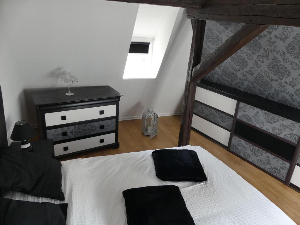 - une chambre avec un lit blanc et une commode noire dans l'établissement Appart chaleureux, à Colmar