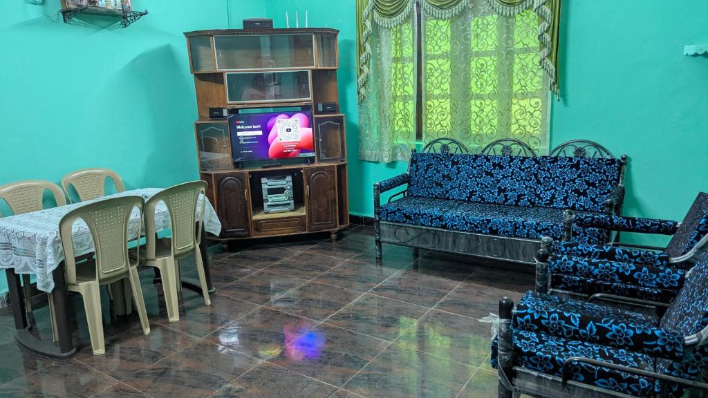 a living room with a couch and a table and a tv at Villa Estrela Holiday Escape in Betalbatim