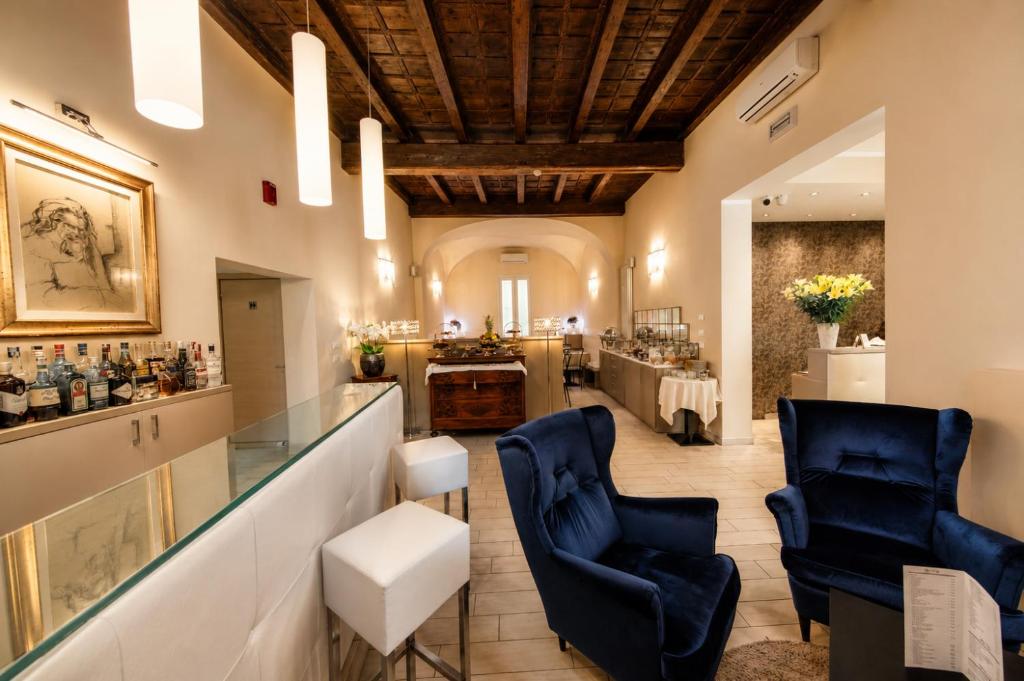 a salon with two blue chairs and a bar at Albergo Rossini 1936 - Small & Charming in Bologna