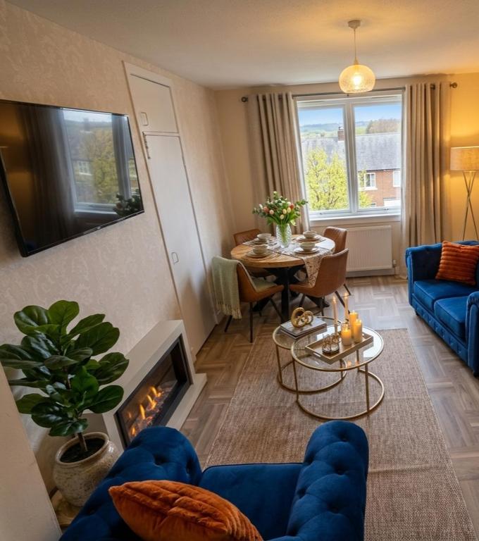 a living room with a blue couch and a table at Number 47 in Hawick