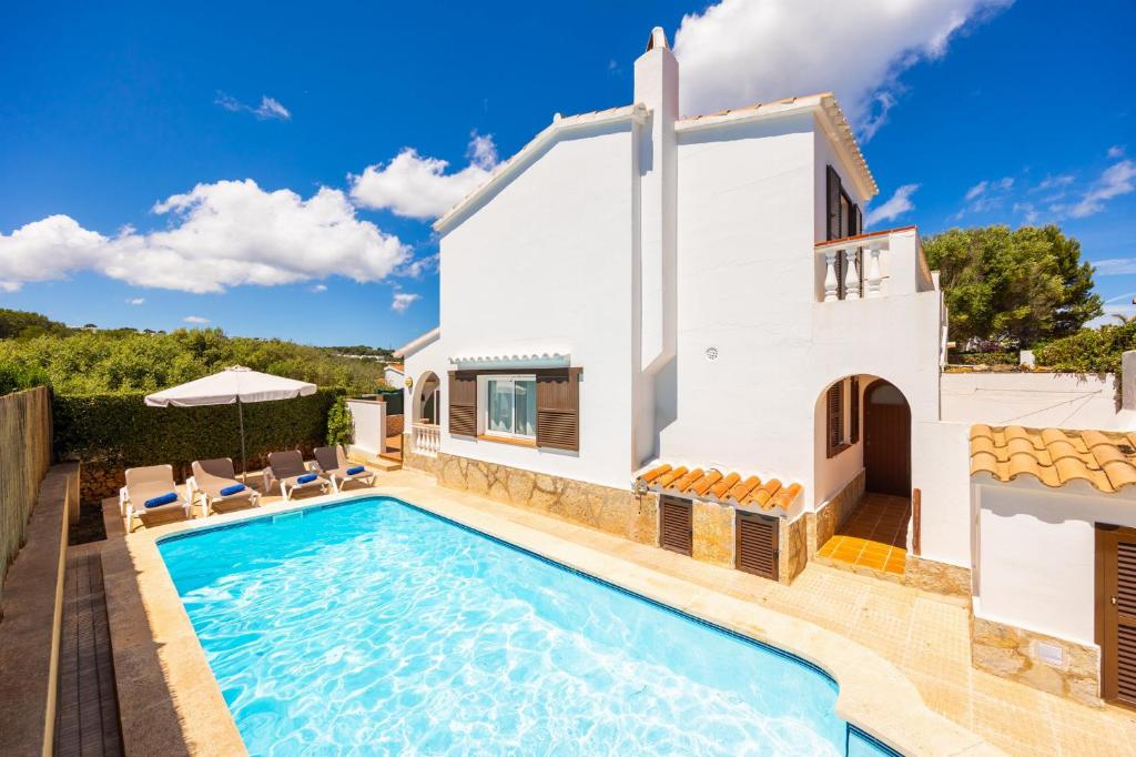a villa with a swimming pool and a house at Villa Ponent in Port d'Addaia