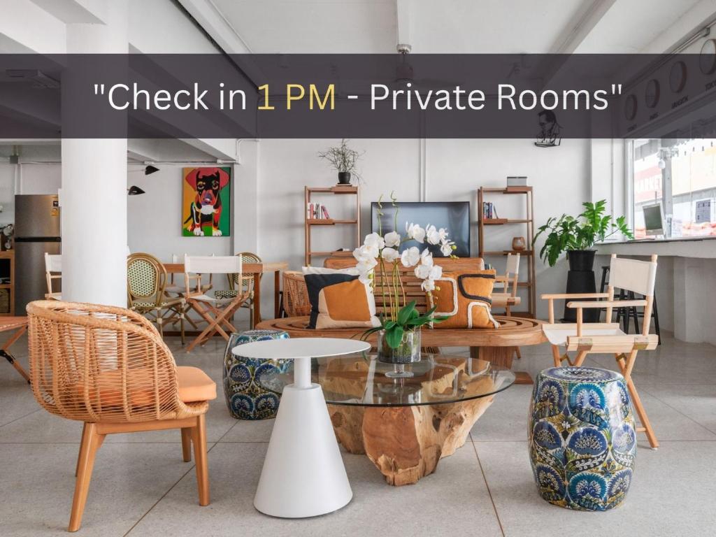 a room with tables and chairs and a sign that reads check in p at Unplugged at Bangrak & Silom Design Hostel in Bangkok