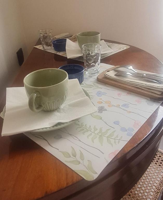 a wooden table with two cups and napkins on it at La chambre de Jeanne in Toul