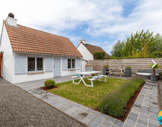 a backyard with a picnic table and a house at Zeevibes - Sunparks - Waterpret - gratis fietsen! in Oostduinkerke