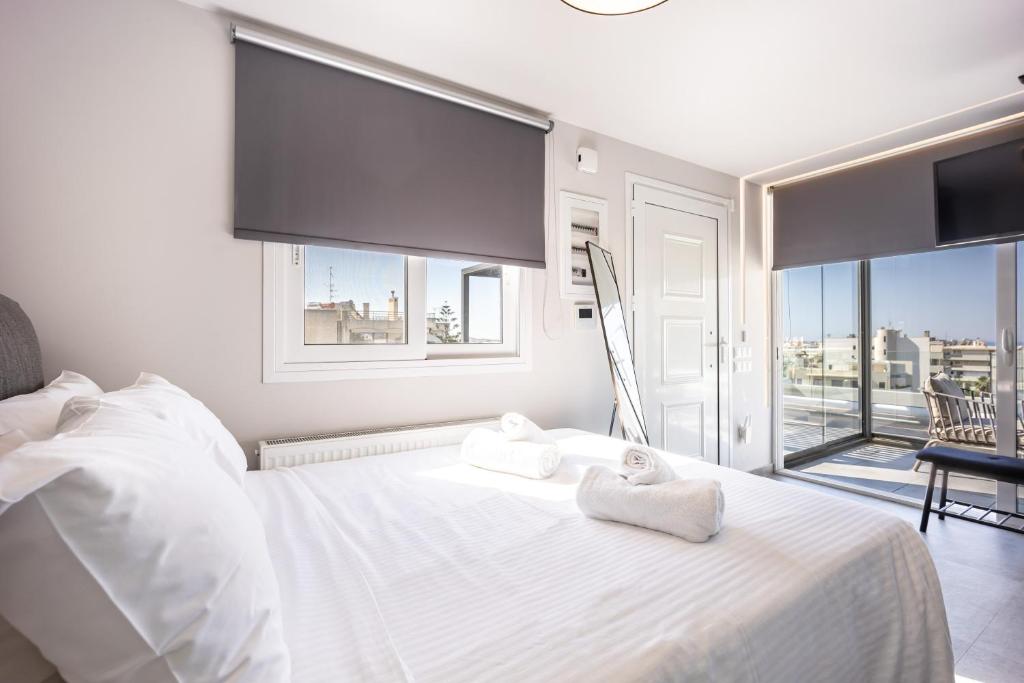 a bedroom with a white bed with towels on it at Glyfadas's Rooftop Blyss in Athens