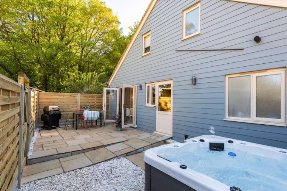 a backyard with a hot tub and a house at The Barn at Thorpewood in Thorpe Market