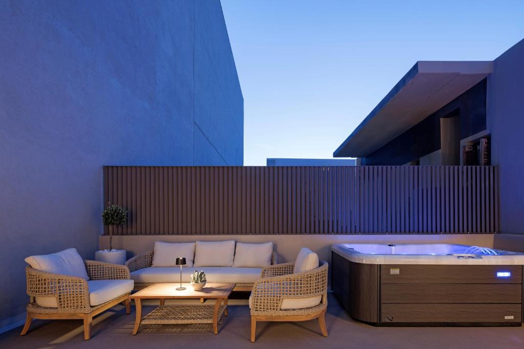 a patio with a hot tub and a table and chairs at Heronia Suites in Karistos