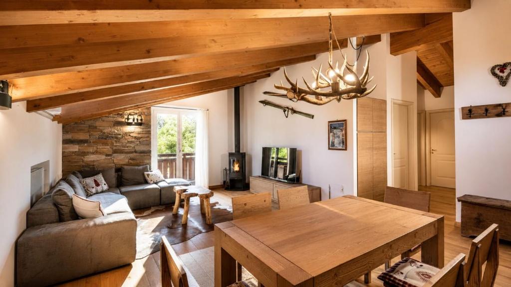 a living room with a wooden table and a dining room at Chalet la Segheria in Temù