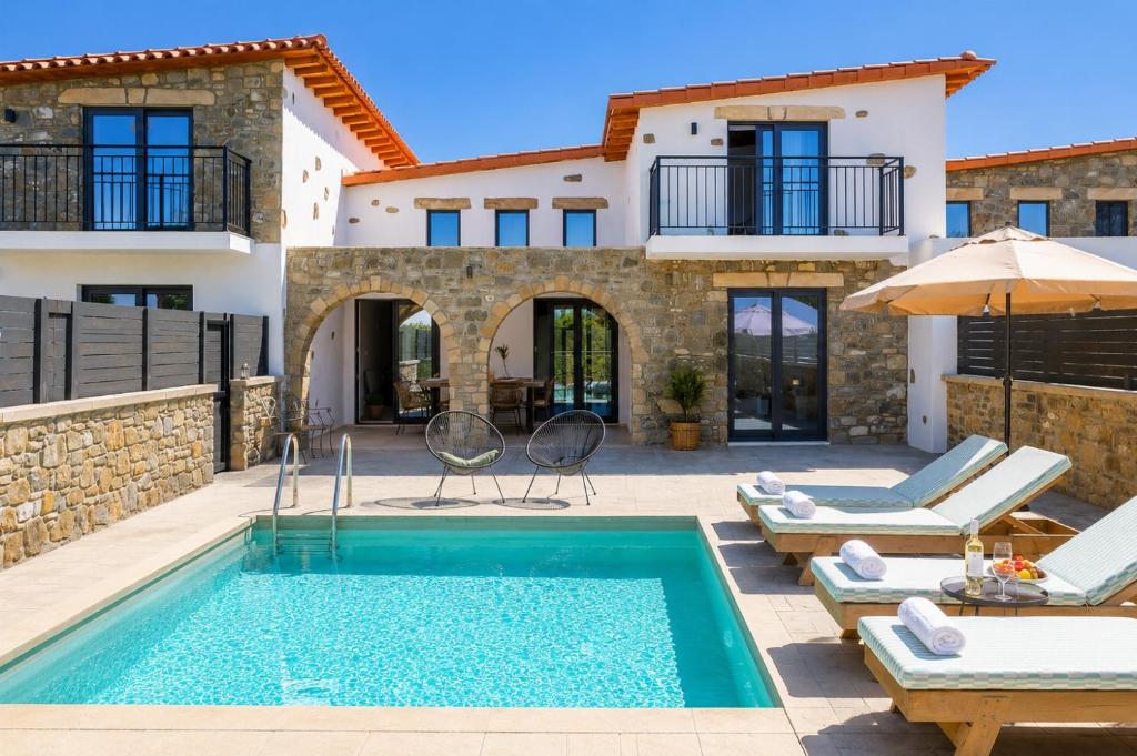 a villa with a swimming pool and a house at La Casa Di Pietre 2 in Kiotari