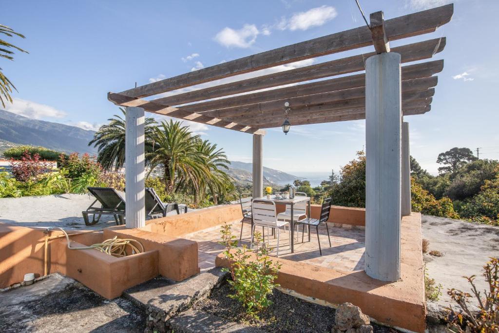 a patio with a pergola with a table and chairs at Casa Asuncion in Breña Alta