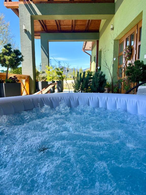 a swimming pool with blue water in a backyard at Apartmán Ranč in Martin