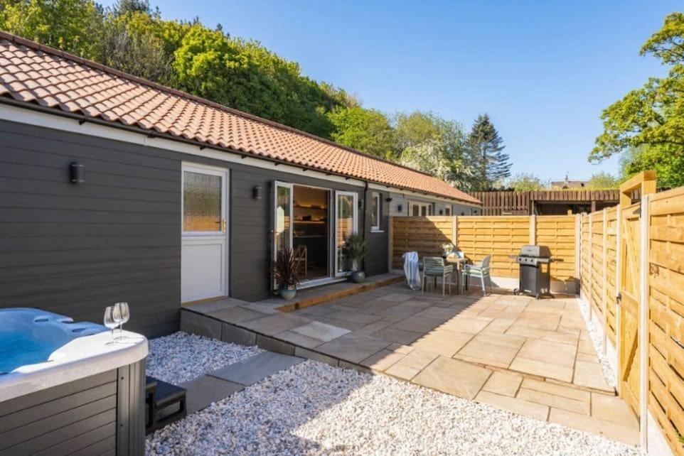 a house with a patio and a fence at The Cove at Thorpewood in Thorpe Market