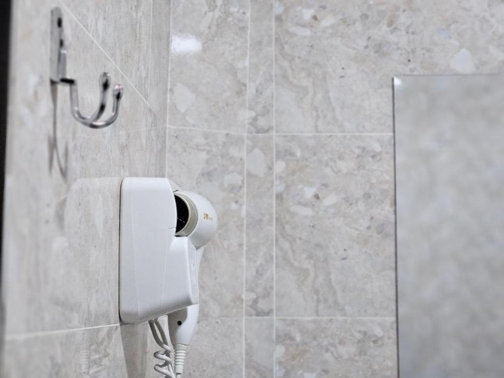 a bathroom with a toilet paper dispenser on the wall at Air Ravan Tashkent in Katartal