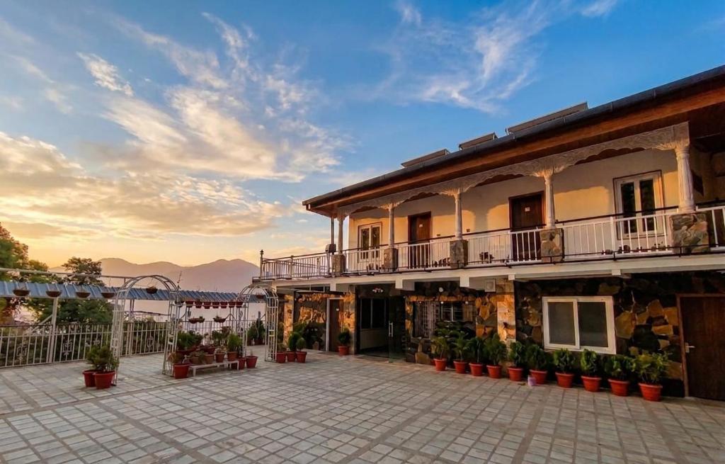 a building with a courtyard with potted plants at Hotel Oakland Landour in Mussoorie