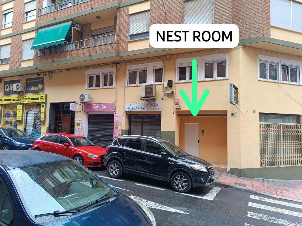 a street with cars parked in front of a building at Nest Room in Alicante