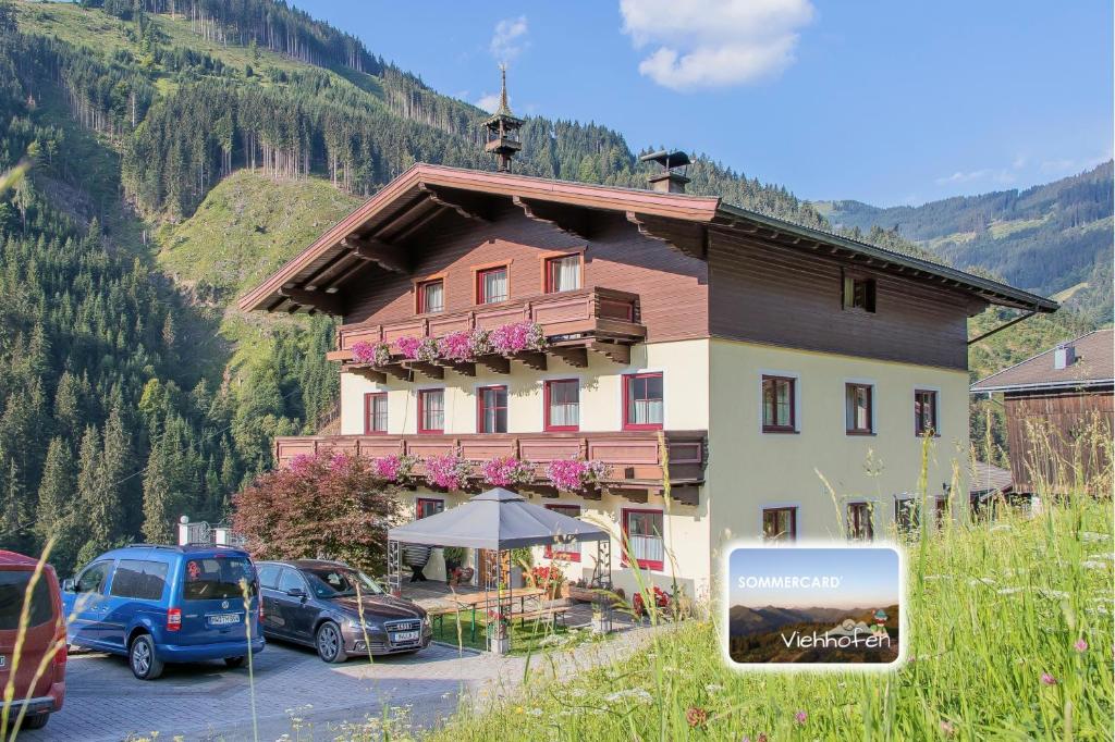 a large building with cars parked in front of it at Hinterbichlhof - Apartments in Viehhofen