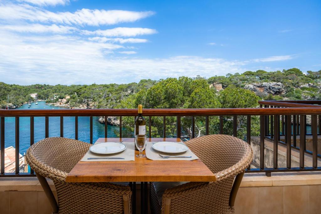 a table with a bottle of wine on a balcony at Cala Figuera Apartment 4b in Cala Figuera