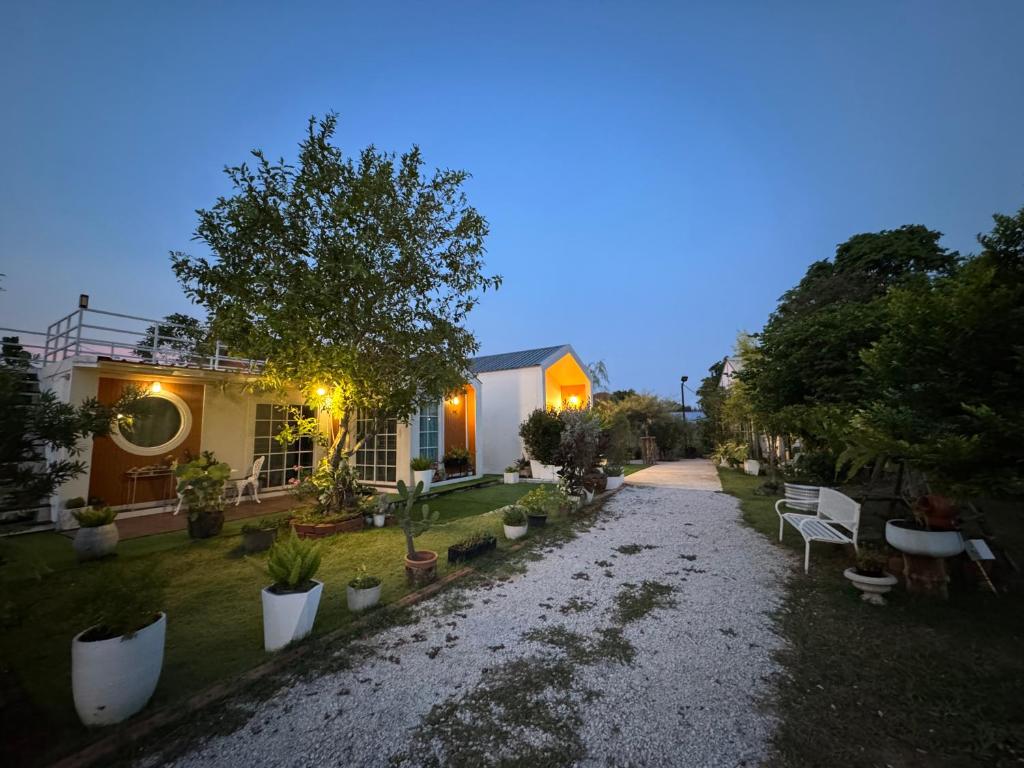 a house with a gravel driveway in front of a house at Good life home in U Tapao