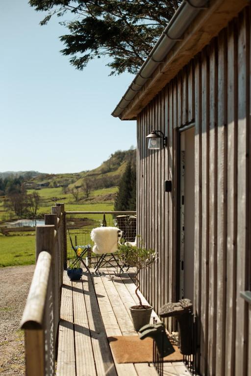 a wooden deck with a chair and a door at Saltspring Lodge in Oban