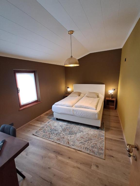 a bedroom with a white bed and a window at DolomitiBel Garibaldina in Belluno