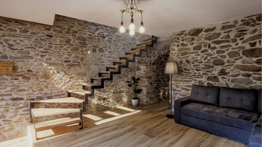 a living room with a stone wall and a staircase at Chalet Ferrari in Ponte di Legno