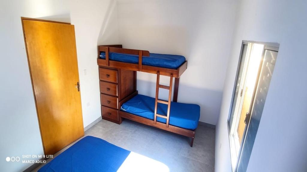 a small room with two bunk beds and a door at Casa Ubatuba in Ubatuba
