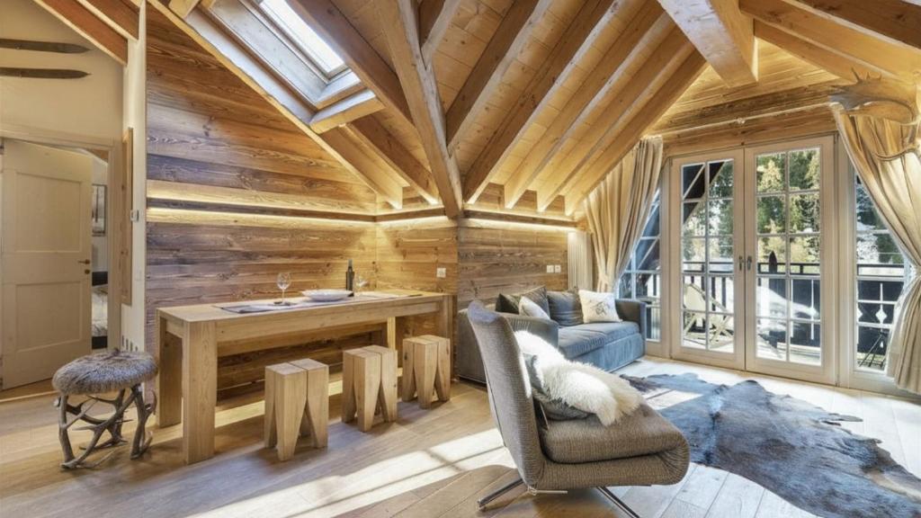a living room with a wooden wall at Alpen Chalet in Ponte di Legno