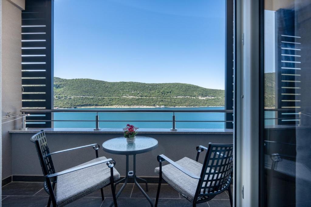a balcony with a table and two chairs and a window at Villa Petra in Neum