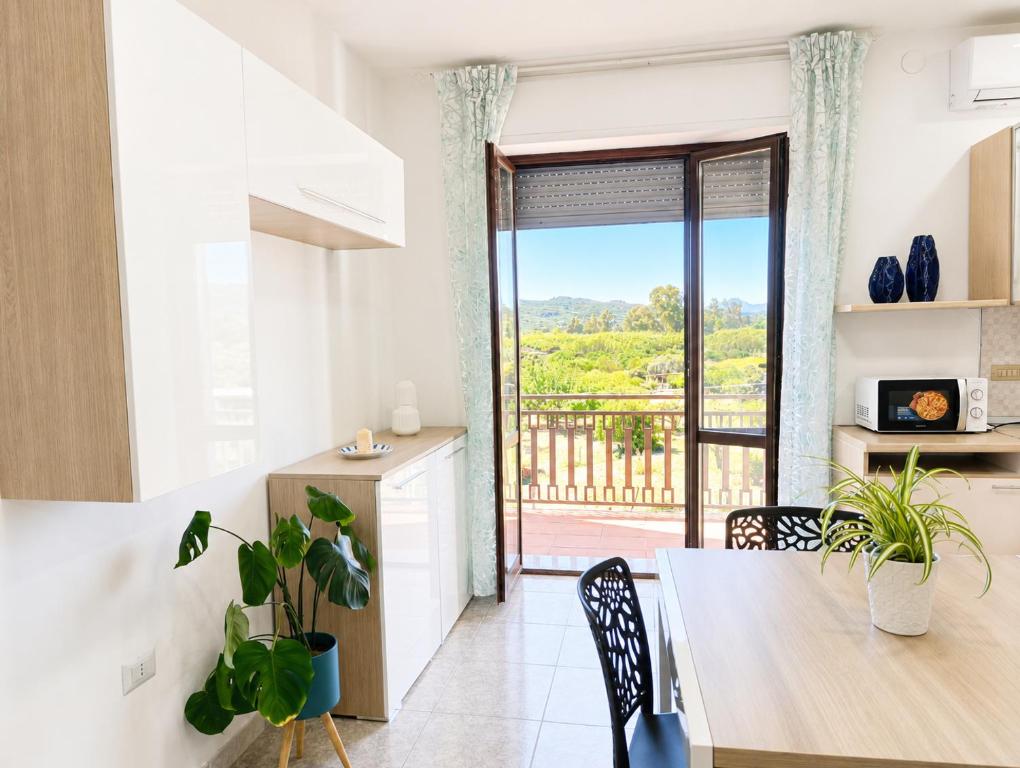 a kitchen and dining room with a view of a balcony at Center Room Tortolì wifi, AC, free parking, city center at 100 m in Tortolì