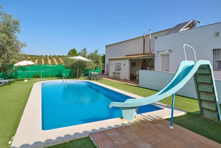 a blue swimming pool with a slide in a yard at VTAR CASILLA MIGUELIN in Montilla