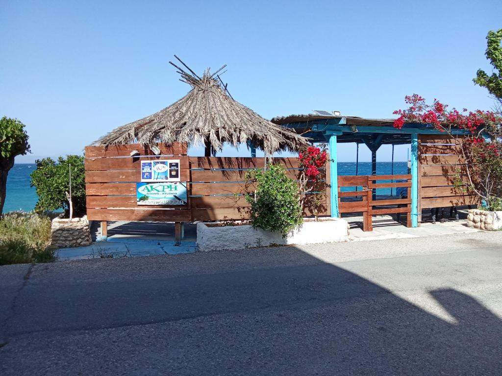 a small hut with a straw roof on the beach at Akri Rooms in Akrata