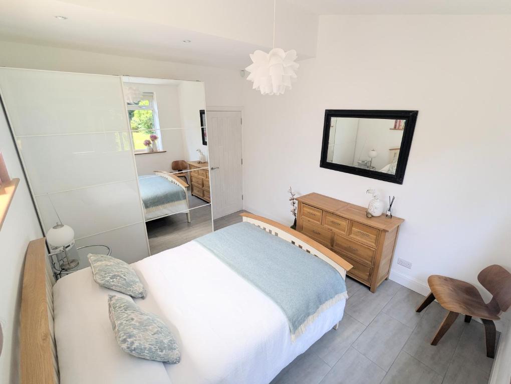 a bedroom with a large bed and a mirror at New Barnet Fresh Apartment in New Barnet