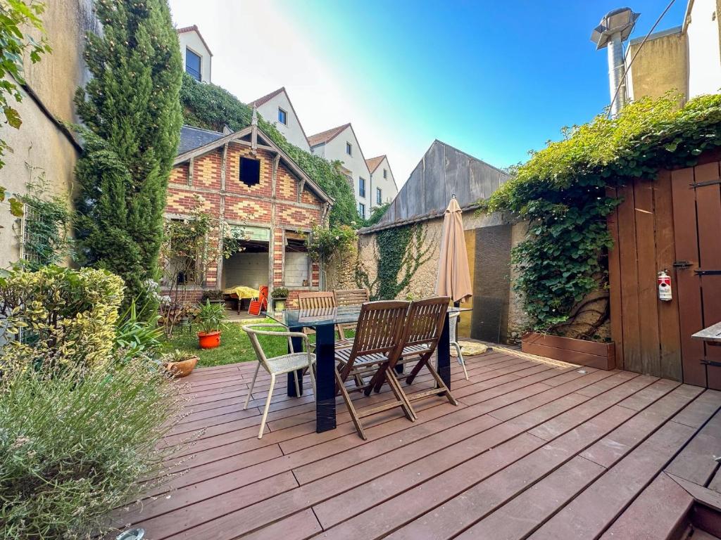 a patio with a table and chairs on a deck at Logement entier hyper centre Chartres in Chartres