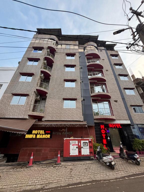 a tall building with windows and a street at Hotel Shifa Manor in Chāībāsa