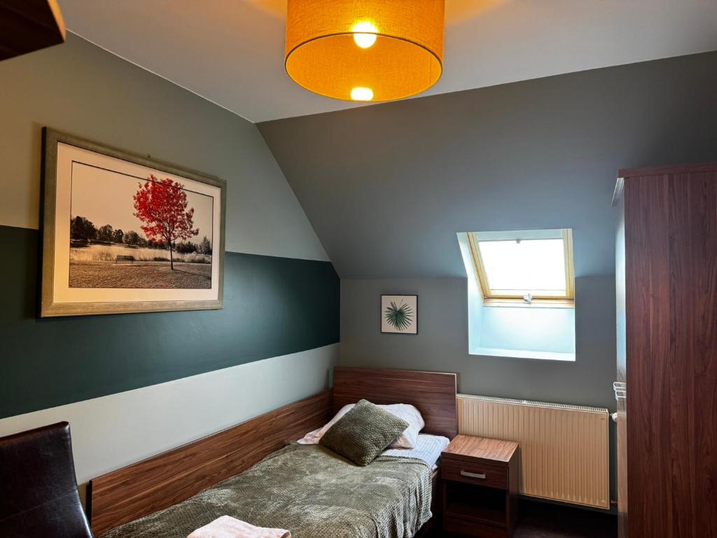 a small bedroom with a bed and a window at Garden Zajazd in Rzeszów