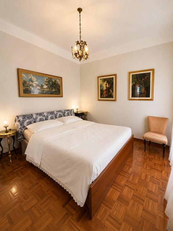 a bedroom with a large bed and a chandelier at Charm Studio - Large private terrace, Masserano in Masserano