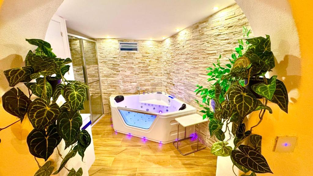 a bathroom with a bath tub and some plants at 16 Casita con Jacuzzi privado in Gran Alacant