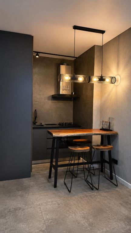 a kitchen with a wooden table and some chairs at Hostly, New Boulevard Prime Stay in Batumi
