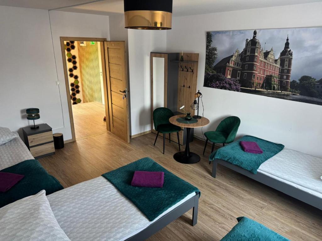 a room with two beds and a table with purple pillows at Krause Park in Łęknica