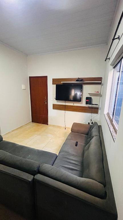 a living room with a couch and a flat screen tv at Casa California - espaçosa in Formosa