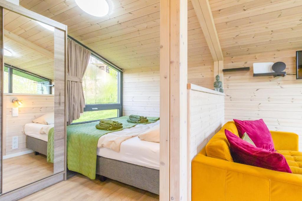 a bedroom with a bed and a couch in a room at Naturverliebt am Diemelsee - Tiny House Wiesenblick in Heringhausen
