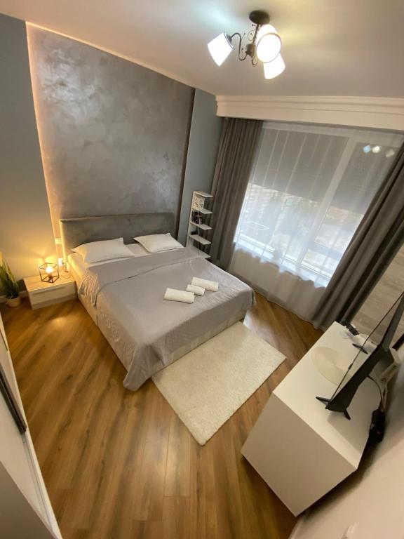 ein Schlafzimmer mit Bett, Schreibtisch und Fenster in der Unterkunft M&M Apartments CSV Home in Cluj-Napoca