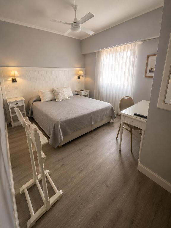 a bedroom with a bed and a desk and a chair at Prince Hotel in Mar del Plata