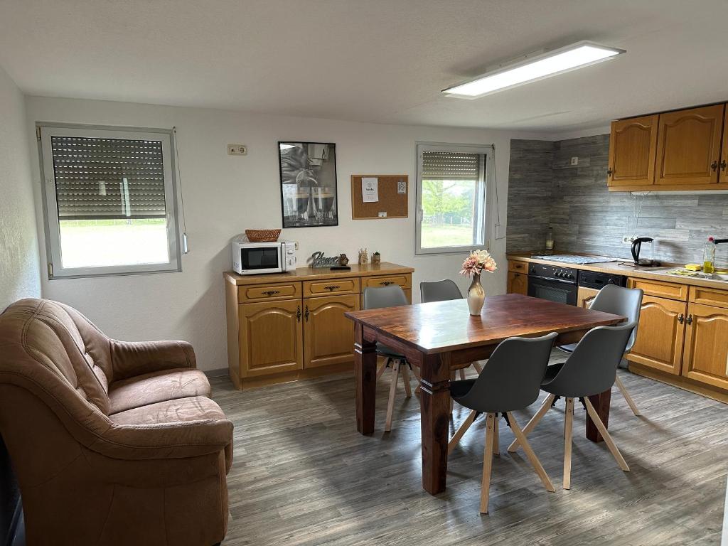 a kitchen with a wooden table and a table and chairs at Casa Melina in Bernsdorf