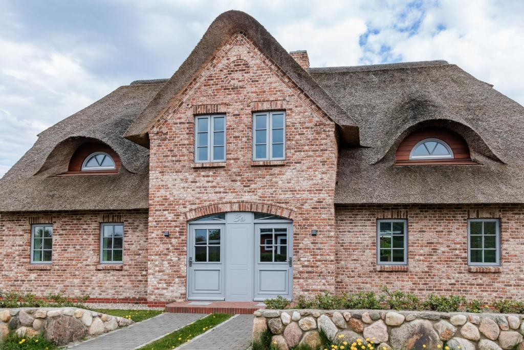 a house with a thatched roof at Wattenkieker in Borgsum