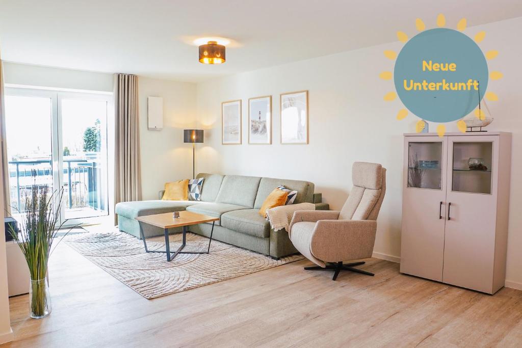 a living room with a couch and a chair at Küste33 34 in Tossens
