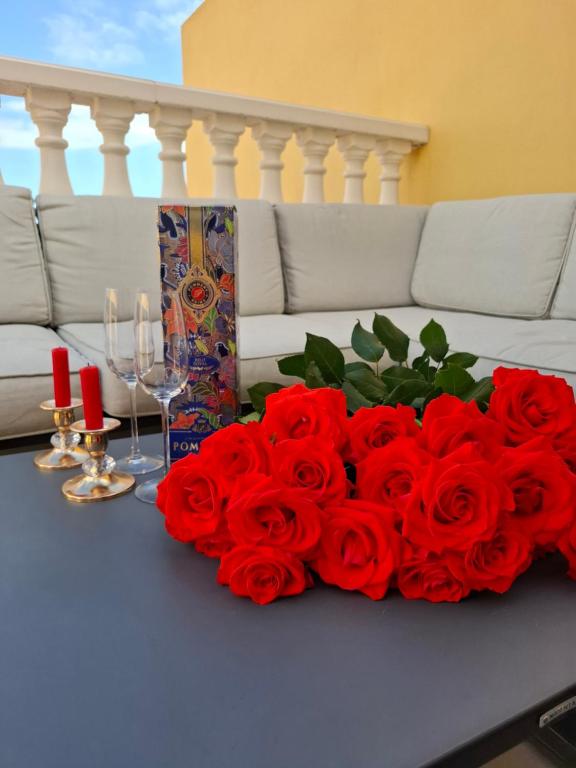 a bouquet of red roses on a table with a couch at Veiw Luxury Apartment in Adeje