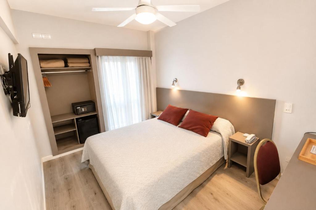 a small bedroom with a bed and a television at Hotel Vip´s in Mar del Plata
