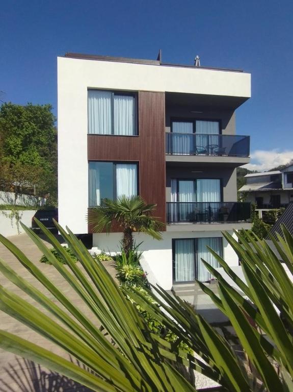 a building with a palm tree in front of it at Boutique Hotel Sleep and Wine in Batumi
